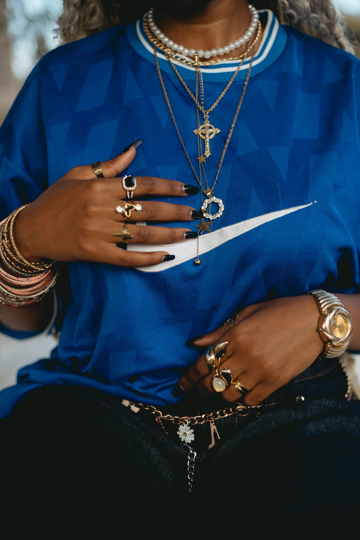 Woman is wearing jewelry and a blue nike shirt.