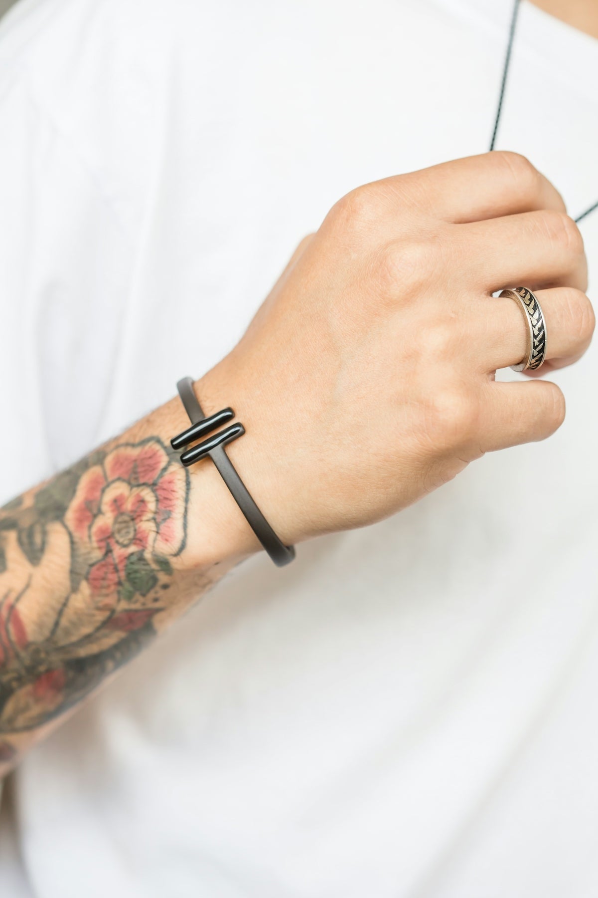 A person displays jewelry and tattoos.