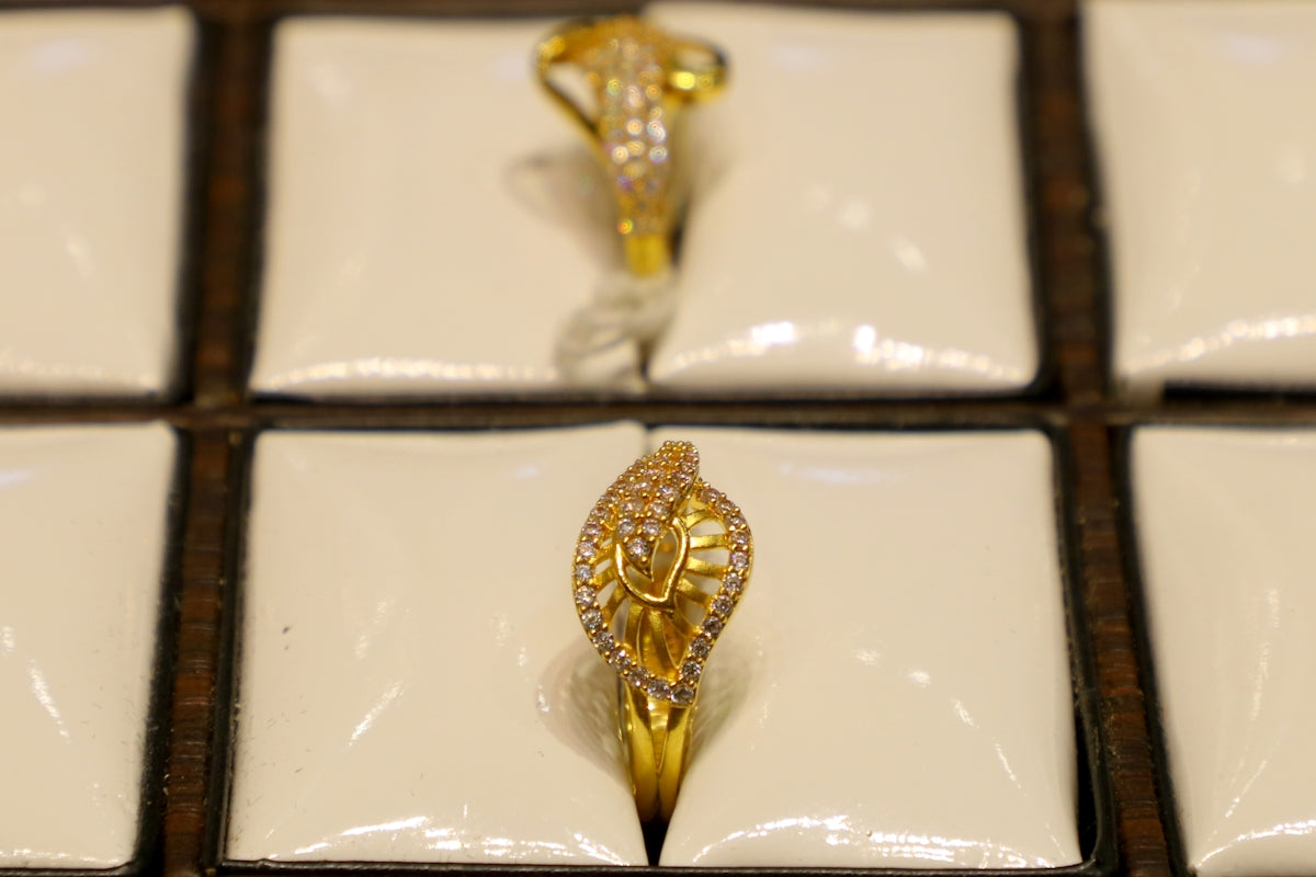 Two ornate gold rings with diamonds on display.