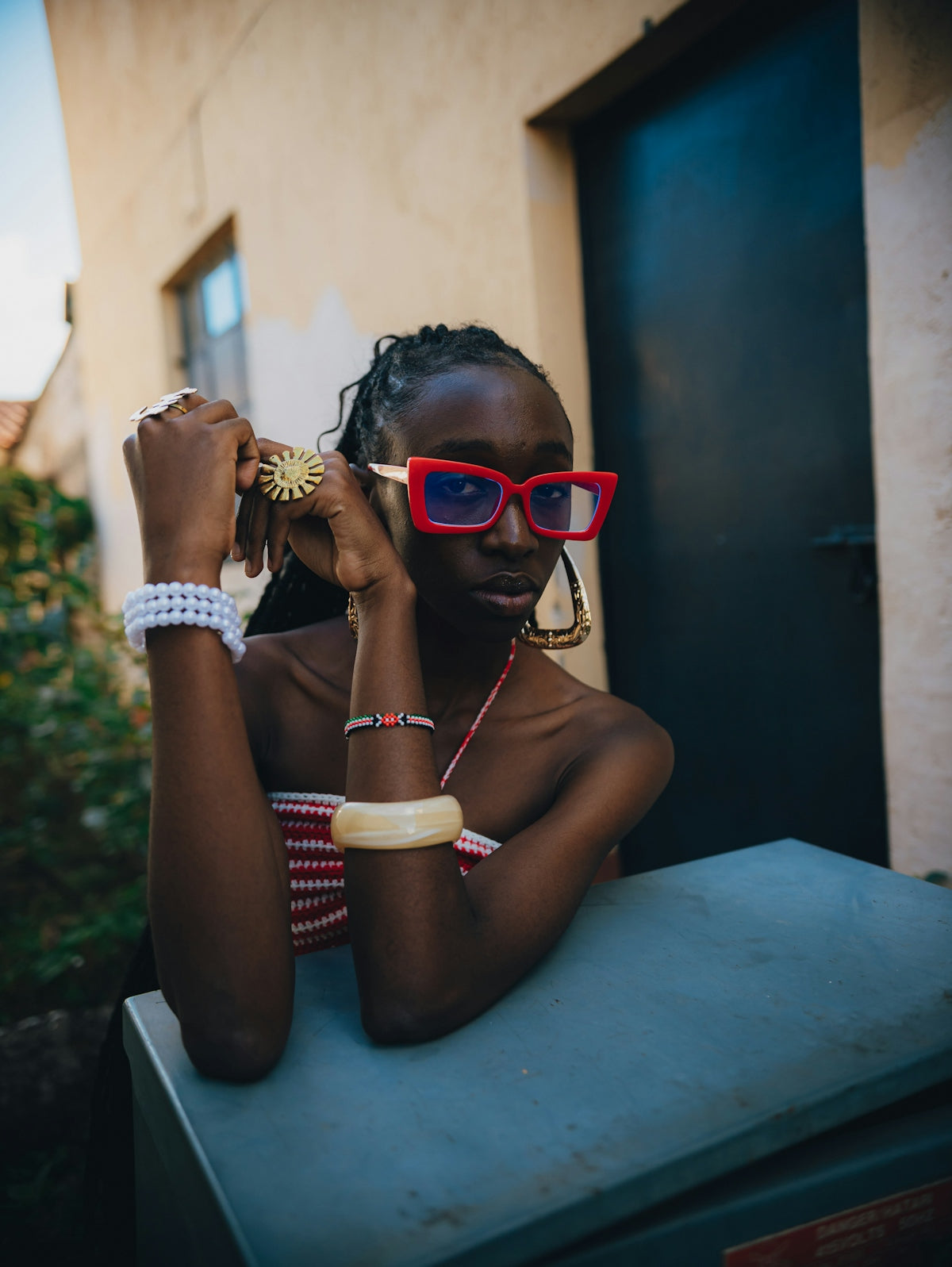 Young woman with bold jewelry and red glasses